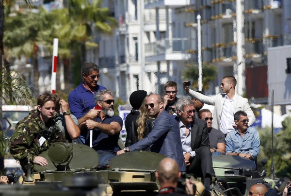 Cast members Sylvester Stallone, Mel Gibson, Jason Statham, Harrison Ford, Arnold Schwarzenegger and Antonio Banderas  pose on a tank as they arrive on the Croisette to promote the film "The Expendables 3" during the 67th Cannes Film Festival in Cannes