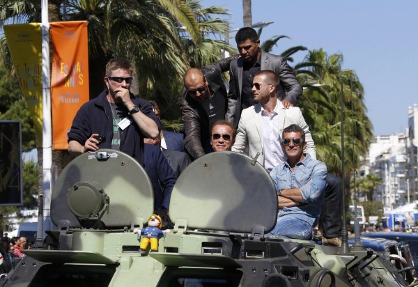 Cast members Victor Ortiz, Arnold Schwarzenegger, Victor Ortiz, Glen Powell and Antonio Banderas pose on a tank as they arrive on the Croisette to promote the film "The Expendables 3" during the 67th Cannes Film Festival in Cannes